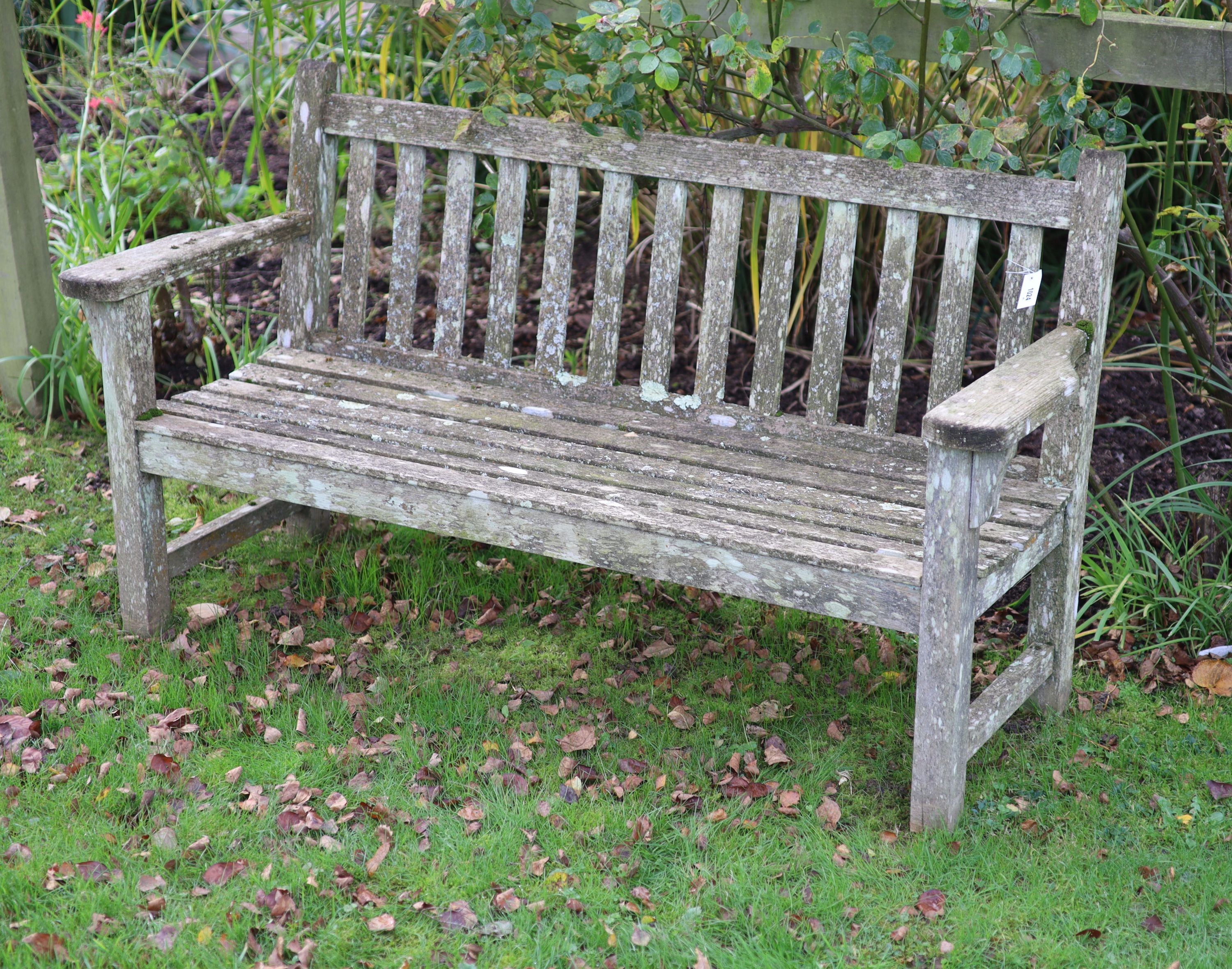 A pair of weathered teak garden benches, width 158cm